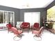 Enclosed porch with seating and a ceiling fan to create a comfortable and inviting outdoor living space at 18956 Sw 93Rd Loop, Dunnellon, FL 34432