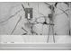 Close up of modern bathtub featuring marble tile, waterfall faucet, and hand-held sprayer at 19939 Sw 96Th Pl, Dunnellon, FL 34432