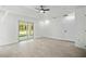 Bright bedroom with tile floors, ceiling fan, and sliding glass doors to the backyard at 19939 Sw 96Th Pl, Dunnellon, FL 34432
