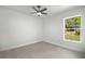 Well-lit bedroom featuring a large window showcasing the greenery outside and a neutral color scheme at 19939 Sw 96Th Pl, Dunnellon, FL 34432
