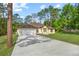 Charming single-story home with a manicured lawn, mature trees, and long driveway at 19939 Sw 96Th Pl, Dunnellon, FL 34432
