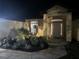 Well-lit home exterior at night showcases manicured landscaping, walkway, and illuminated entrance at 19939 Sw 96Th Pl, Dunnellon, FL 34432