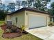Attached garage with landscaping near the exterior of home at 19939 Sw 96Th Pl, Dunnellon, FL 34432