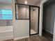 Updated bathroom features a tiled walk-in shower with glass door and black trim plus a window for natural light at 20652 Sw Cardinal Ave, Dunnellon, FL 34431