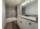 Updated bathroom with granite vanity top, framed mirror, recessed lights, and tiled shower over tub at 20652 Sw Cardinal Ave, Dunnellon, FL 34431