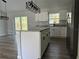 Stylish kitchen featuring an island with granite countertops, stainless steel appliances, and modern lighting at 20652 Sw Cardinal Ave, Dunnellon, FL 34431
