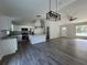 Open-concept living space with a kitchen featuring stainless steel appliances and modern lighting fixtures at 20652 Sw Cardinal Ave, Dunnellon, FL 34431