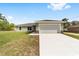 Charming single-story home featuring a well-manicured lawn and a spacious two-car garage at 207 Juniper Loop Cir, Ocala, FL 34480