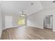 Living room featuring wood floors, a ceiling fan, and access to the bathroom at 207 Juniper Loop Cir, Ocala, FL 34480
