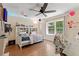 Cozy bedroom with wood floors, natural light, a ceiling fan, and decorated with playful decorative accents at 21884 Sw 88Th Lane Rd, Dunnellon, FL 34431
