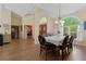Open-concept dining room with hardwood floors, chandelier, and a large window for plenty of natural light at 21884 Sw 88Th Lane Rd, Dunnellon, FL 34431