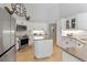 Well-lit kitchen boasts white cabinetry, granite countertops, a center island, and stainless steel appliances at 21884 Sw 88Th Lane Rd, Dunnellon, FL 34431