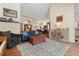 Bright living room featuring a comfortable blue sofa, area rug, and an open floor plan to the dining area at 21884 Sw 88Th Lane Rd, Dunnellon, FL 34431
