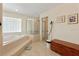 Bright main bathroom featuring a soaking tub, separate shower, and tile flooring at 21884 Sw 88Th Lane Rd, Dunnellon, FL 34431