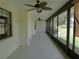 Long, enclosed porch with ceiling fans, offering views of the yard at 2865 Se 37Th St, Ocala, FL 34471