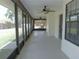 Long, enclosed porch with ceiling fans, offering views of the yard at 2865 Se 37Th St, Ocala, FL 34471