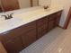 Bathroom featuring a vanity with dual sinks, tile floor, and brown cabinets at 2865 Se 37Th St, Ocala, FL 34471