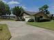 Home featuring a long driveway leading to a two-car garage, complemented by lush green lawns at 2865 Se 37Th St, Ocala, FL 34471