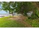 Expansive backyard with mature trees, leading to a waterfront view at 31 Se Chinica Dr, Summerfield, FL 34491