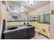 Bathroom featuring double sinks with black fixtures, light yellow walls, and tile flooring at 31 Se Chinica Dr, Summerfield, FL 34491