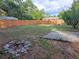 Spacious backyard with a wooden fence, fire pit, and a patio with mosaic tiles at 33 Pecan Pass Trl, Ocala, FL 34472