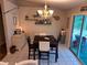 Cozy dining area with chandelier lighting, tile floors, and a slider to the outdoors at 33 Pecan Pass Trl, Ocala, FL 34472