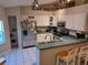 Efficient kitchen featuring white cabinetry, stainless steel appliances, and a breakfast bar for casual dining at 33 Pecan Pass Trl, Ocala, FL 34472