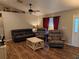 Inviting living room featuring wood floors, neutral walls, a ceiling fan, and lots of natural light at 33 Pecan Pass Trl, Ocala, FL 34472