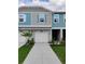 Two-story townhome featuring a one-car garage, charming blue shutters, and fresh landscaping at 3571 Se 37Th Ct, Ocala, FL 34480