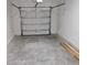A two-car garage with a concrete floor and a metal garage door at 3571 Se 37Th Ct, Ocala, FL 34480