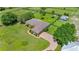 Aerial view of a single story home with manicured lawn, mature trees and curving driveway at 5415 Nw 100Th St, Ocala, FL 34482