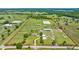 Expansive aerial view of a horse farm with paddocks, barns, riding arena, and residence, all within a clearly defined perimeter at 5415 Nw 100Th St, Ocala, FL 34482
