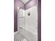 Stylish bathroom with a white subway tile shower and black and white patterned floor at 5415 Nw 100Th St, Ocala, FL 34482