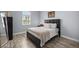 Cozy bedroom with a comfortable queen-sized bed, neutral walls, and wood-look flooring at 5415 Nw 100Th St, Ocala, FL 34482