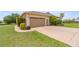 Beige single-story home with a well-maintained lawn and a two-car garage at 5415 Nw 100Th St, Ocala, FL 34482