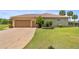 Beige single-story home with a well-maintained lawn and a two-car garage at 5415 Nw 100Th St, Ocala, FL 34482
