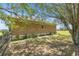Side of the house features a stone facade and is surrounded by lush greenery and mature trees at 5415 Nw 100Th St, Ocala, FL 34482