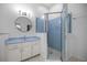 This bathroom features a blue-tiled glass enclosed shower and white vanity at 5415 Nw 100Th St, Ocala, FL 34482