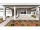 A close up of a cozy covered front porch with manicured landscaping, and gray exterior paint at 5714 Sw 75Th Ave, Ocala, FL 34474