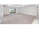 Spacious living room with plush carpet, neutral gray walls, and sliding glass doors overlooking the backyard at 5714 Sw 75Th Ave, Ocala, FL 34474