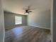 This bedroom features a ceiling fan, wood-look floors, and a window allowing natural light to fill the space at 5799 Sw 207Th Ct, Dunnellon, FL 34431