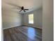 This bedroom features a ceiling fan, wood-look floors, and a window allowing natural light to fill the space at 5799 Sw 207Th Ct, Dunnellon, FL 34431