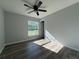 This bedroom features a ceiling fan, wood-look floors, and a window allowing natural light to fill the space at 5799 Sw 207Th Ct, Dunnellon, FL 34431