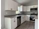 Bright kitchen with modern appliances, white cabinets, granite counters, and gray flooring at 5799 Sw 207Th Ct, Dunnellon, FL 34431