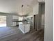 Modern kitchen boasts white cabinets, granite countertops, and an island with designer lighting at 5799 Sw 207Th Ct, Dunnellon, FL 34431