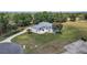 Aerial view of a well-maintained property with mature landscaping, circular driveway, and a pristine, light-colored home at 5819 Ne 72Nd St, Silver Springs, FL 34488