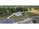 Elevated view of a meticulously kept property with mature landscaping, circular driveway, and an attractive, light-colored home at 5819 Ne 72Nd St, Silver Springs, FL 34488