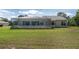 An expansive backyard features a screened-in porch connected to a single-story home, perfect for outdoor living and entertaining at 5819 Ne 72Nd St, Silver Springs, FL 34488