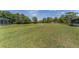 Wide shot of the backyard and large grassy area with a screened in pool at 5819 Ne 72Nd St, Silver Springs, FL 34488