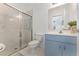 Bright bathroom featuring a glass enclosed shower, white tile and light blue vanity at 5819 Ne 72Nd St, Silver Springs, FL 34488
